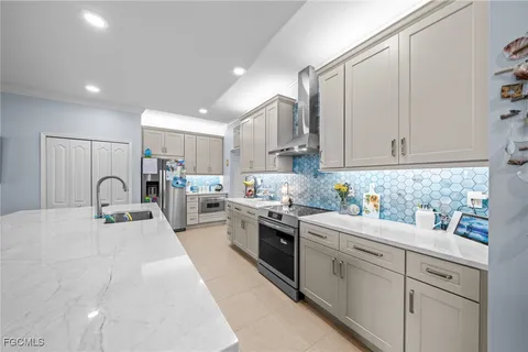 a kitchen with kitchen island granite countertop a sink stainless steel appliances and cabinets