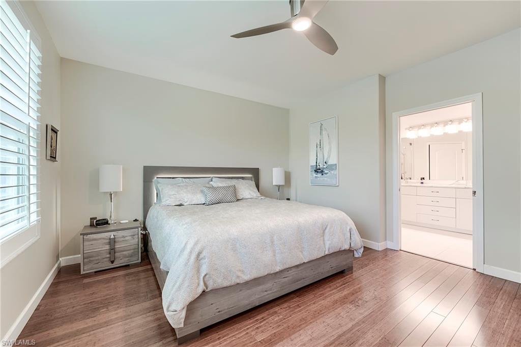 23815 Clear Spring Court, Unit 2105 Estero, FL 34135 - Photo 13 of 37 a bedroom with a bed and wooden floor