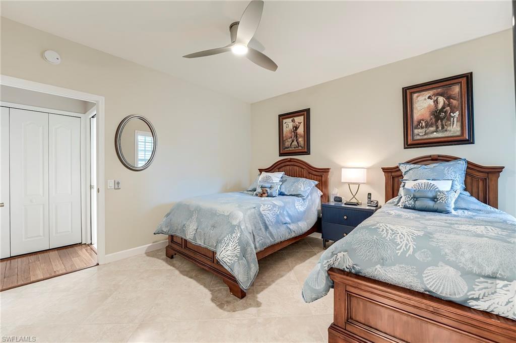 23815 Clear Spring Court, Unit 2105 Estero, FL 34135 - Photo 19 of 37 a spacious bedroom with two bed and a chandelier