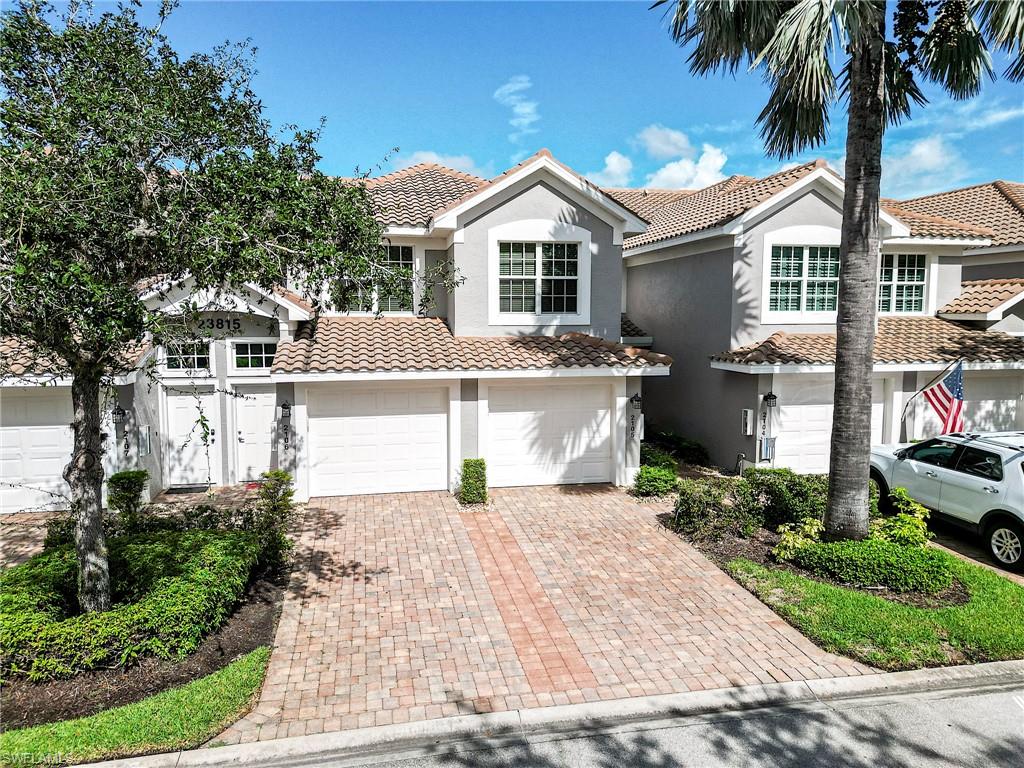 23815 Clear Spring Court, Unit 2105 Estero, FL 34135 - Photo 2 of 37 a front view of a house with a yard and garage