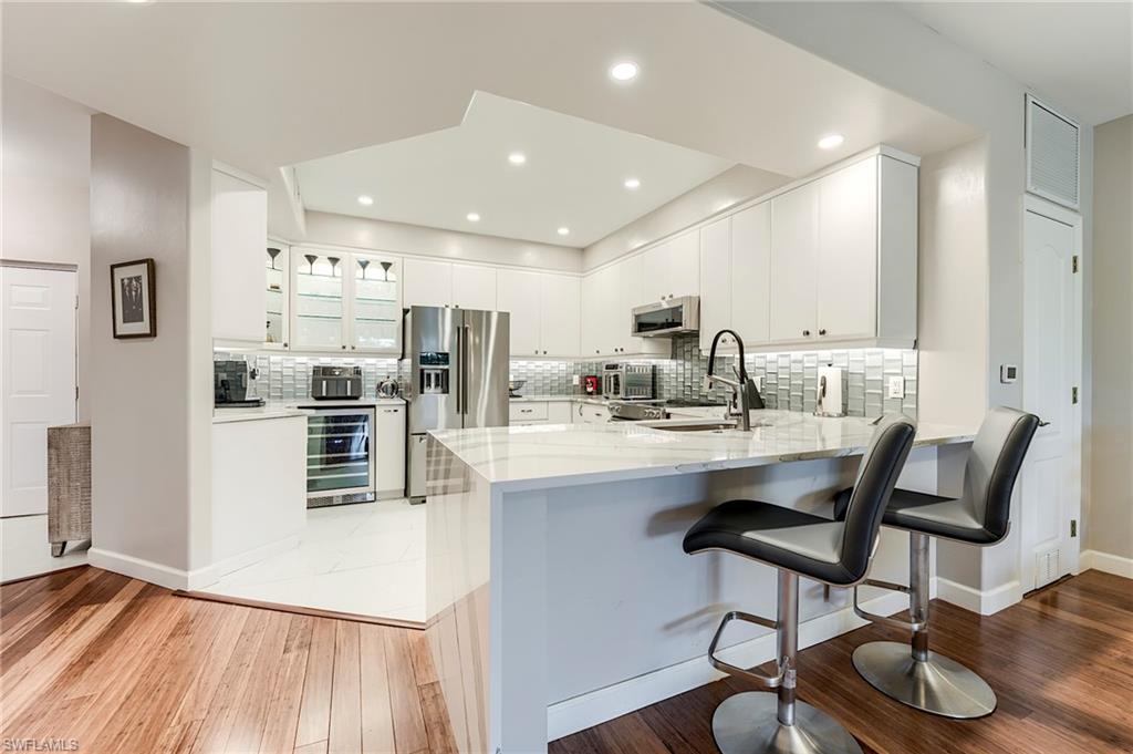 23815 Clear Spring Court, Unit 2105 Estero, FL 34135 - Photo 5 of 37 a kitchen with stainless steel appliances kitchen island granite countertop a sink and cabinets