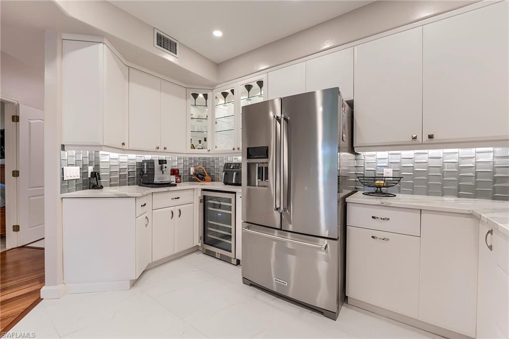 23815 Clear Spring Court, Unit 2105 Estero, FL 34135 - Photo 6 of 37 a kitchen with stainless steel appliances white cabinets and a refrigerator