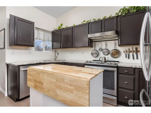 a kitchen with kitchen island a counter top space cabinets and stainless steel appliances