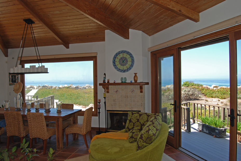 815 Sand Point Road Carpinteria, CA 93013 - Photo 8 of 12 a living room with furniture a fireplace and a floor to ceiling window