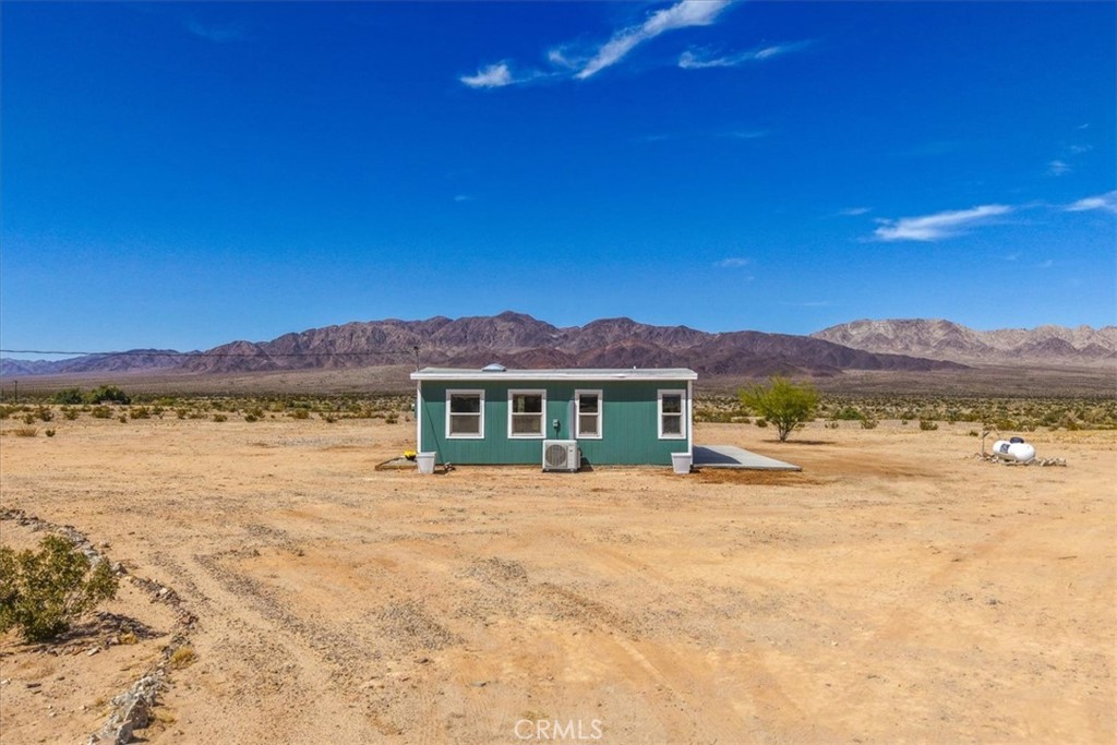 84320 McCombie Road Twentynine Palms, CA 92277 - Photo 34 of 57 a view of a house with a yard and a large tree