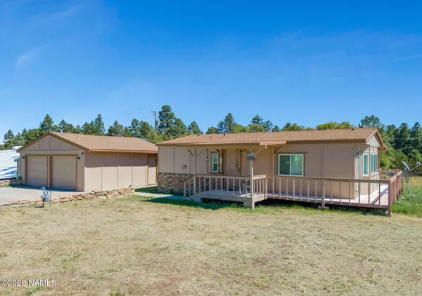 a front view of a house with a yard and potted plants