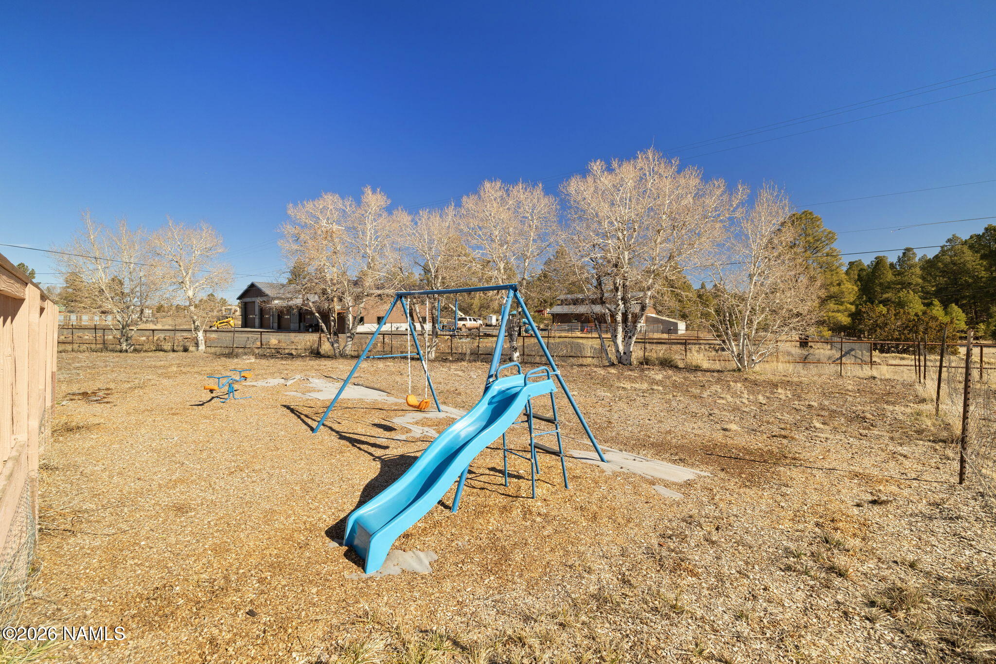 1050 North Arpt Road Williams, AZ 86046 - Photo 26 of 29 a view of a swimming pool with a bench and trees in the background