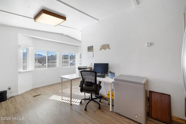 a view of a workspace with furniture and a window