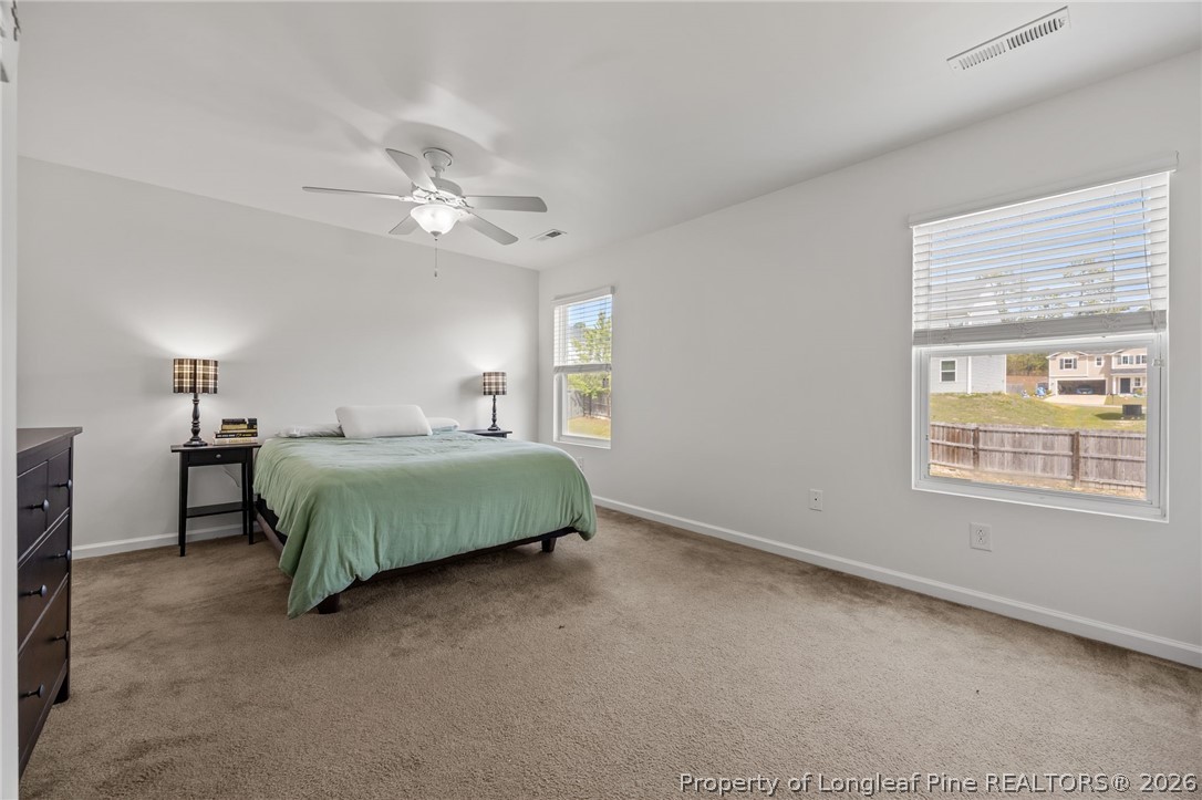 226 River Oak Street Spring Lake, NC 28390 - Photo 23 of 41 a bedroom with a bed chandelier and a window
