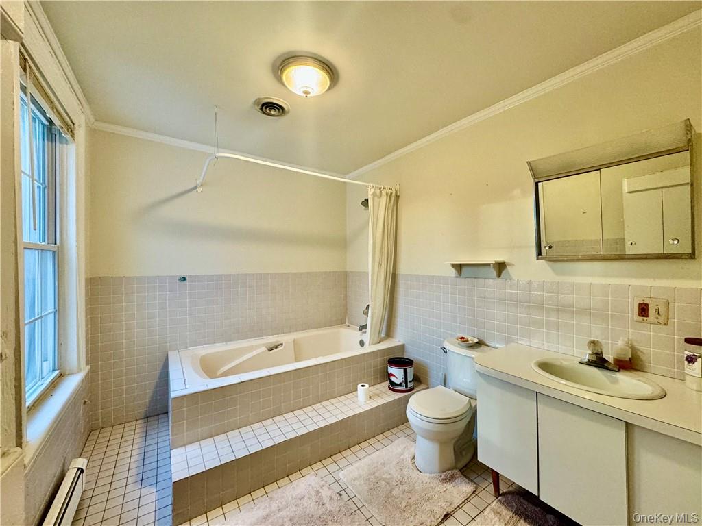 255 Howells Road Middletown, NY 10940 - Photo 33 of 38 2nd floor Full bathroom with a baseboard radiator, tile walls, toilet, vanity, and tile patterned flooring