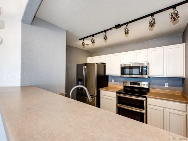 a kitchen with stainless steel appliances a refrigerator stove and microwave