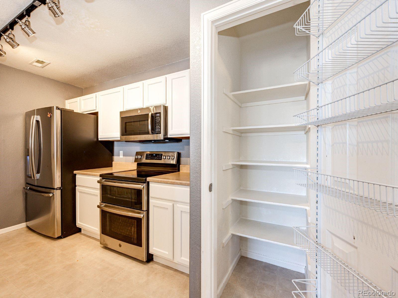 5255 Memphis Street, Unit 122 Denver, CO 80239 - Photo 12 of 26 a view of a kitchen with refrigerator and microwave