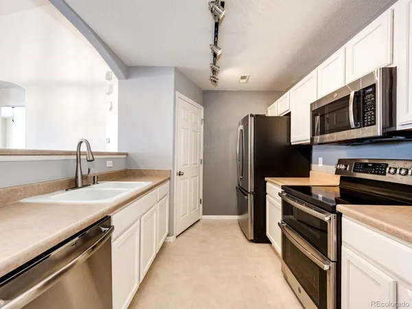 a kitchen with stainless steel appliances a stove microwave and a sink