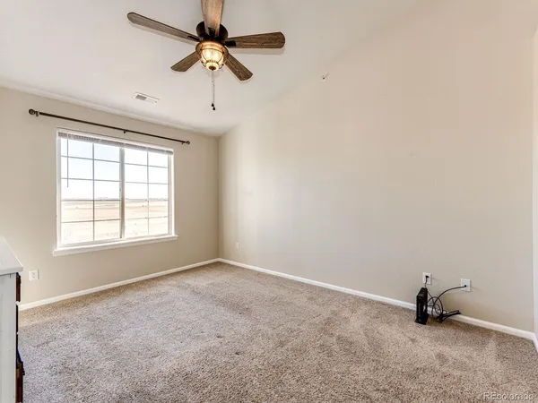 an empty room with a window and a fan