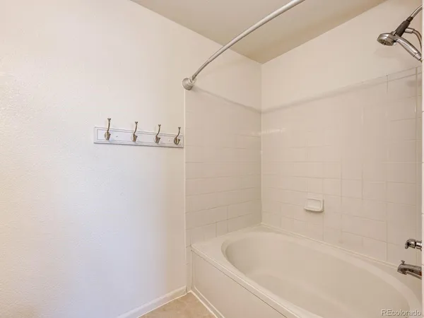 a white bath tub sitting next to a white sink and vanity