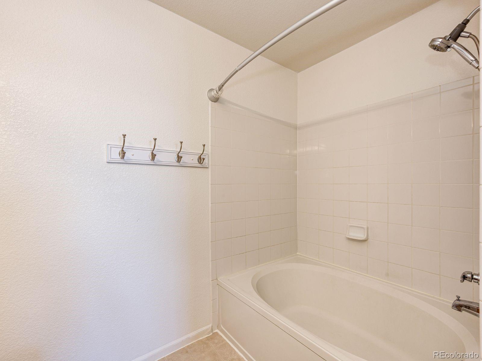 5255 Memphis Street, Unit 122 Denver, CO 80239 - Photo 19 of 26 a white bath tub sitting next to a white sink and vanity