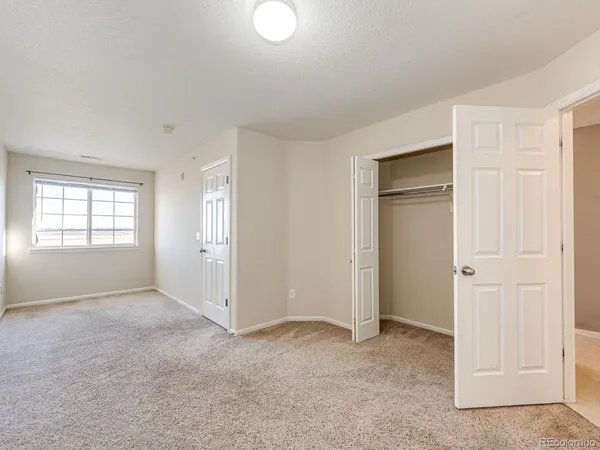 an empty room with windows and closet