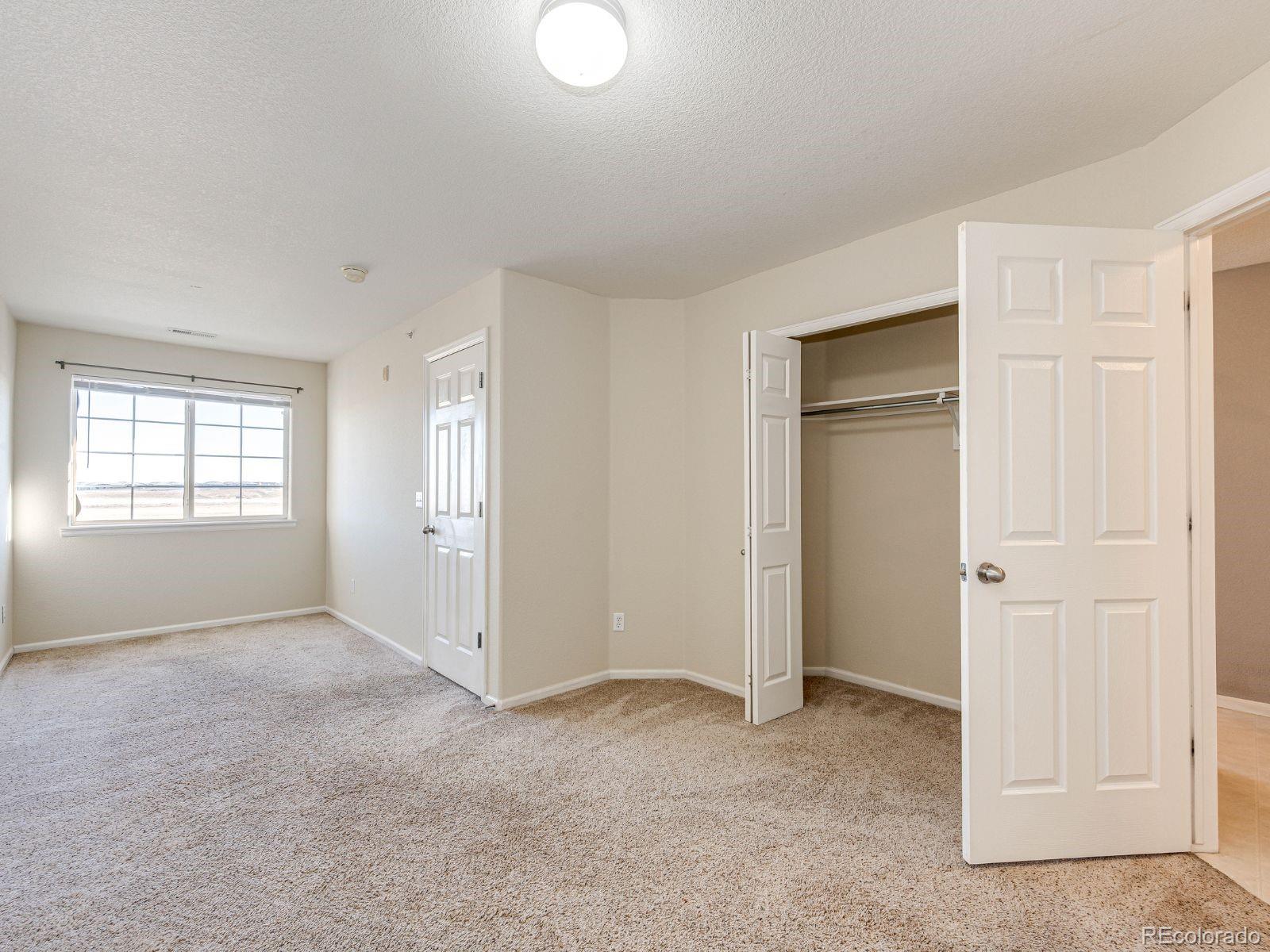 5255 Memphis Street, Unit 122 Denver, CO 80239 - Photo 21 of 26 an empty room with windows and closet
