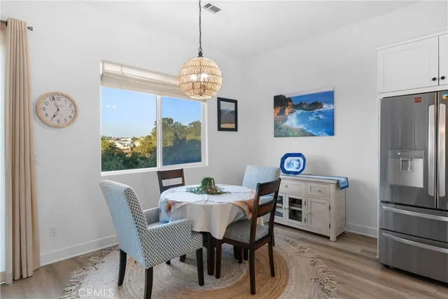 a view of a dining room with furniture a chandelier and wooden floor