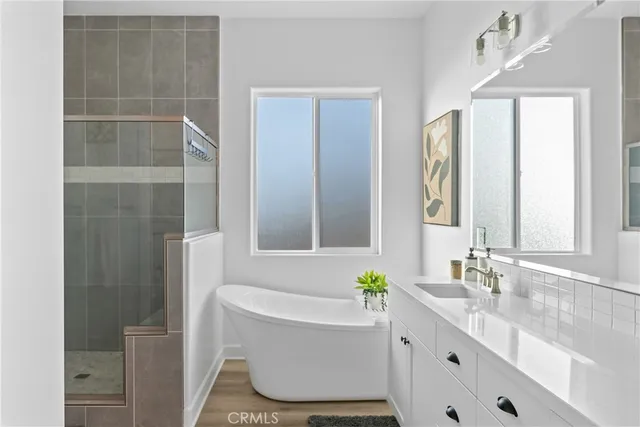 a bathroom with a granite countertop sink and a bathtub
