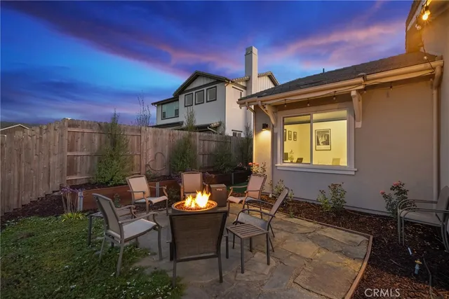 a view of a house with a backyard and sitting area