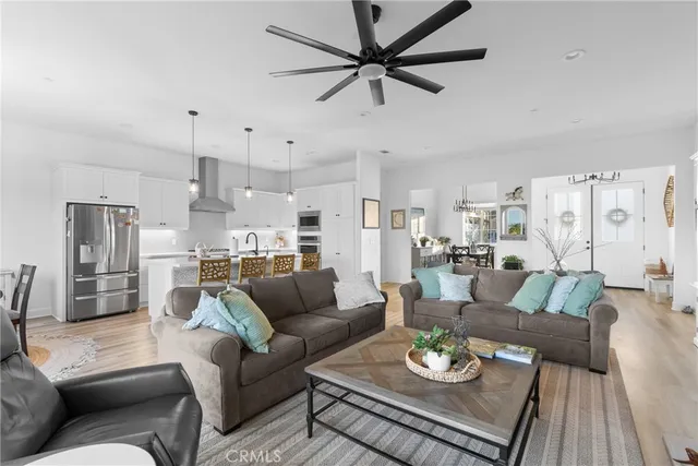 a living room with furniture kitchen view and a chandelier