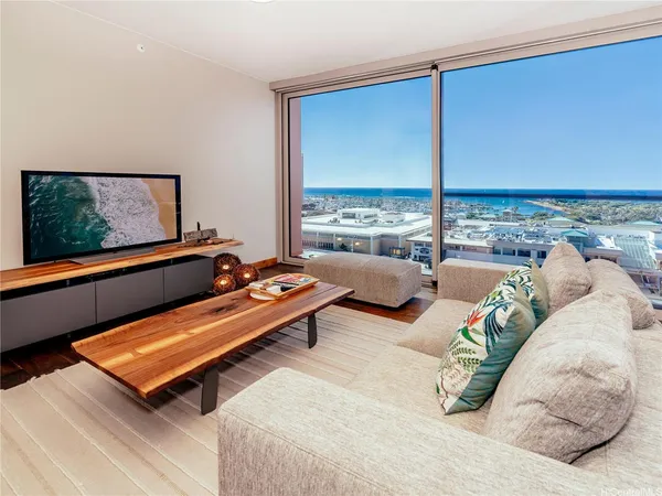 a living room with furniture floor to ceiling window and a flat screen tv