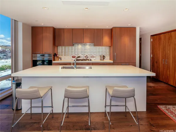 a kitchen with stainless steel appliances a white table chairs and a refrigerator