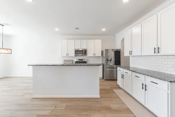 a kitchen with white cabinets stainless steel appliances and sink