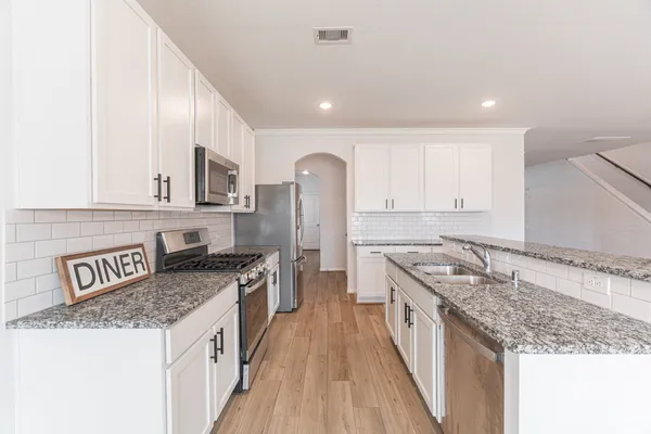 a kitchen with stainless steel appliances granite countertop a stove and a sink