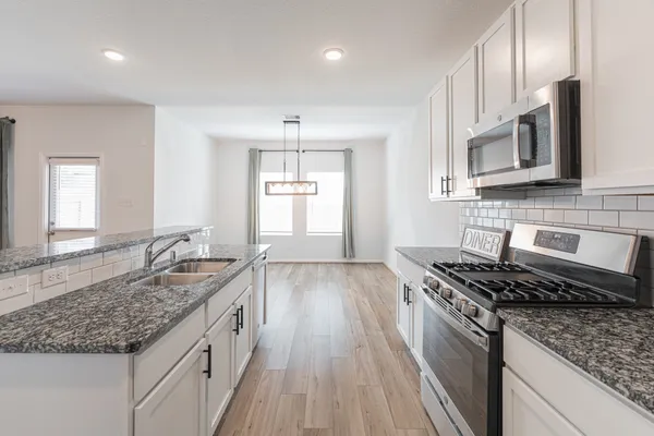 a view of empty room with wooden floor and window