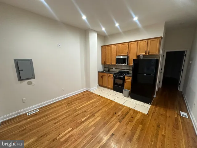 a view of kitchen with wooden floor and refrigerator