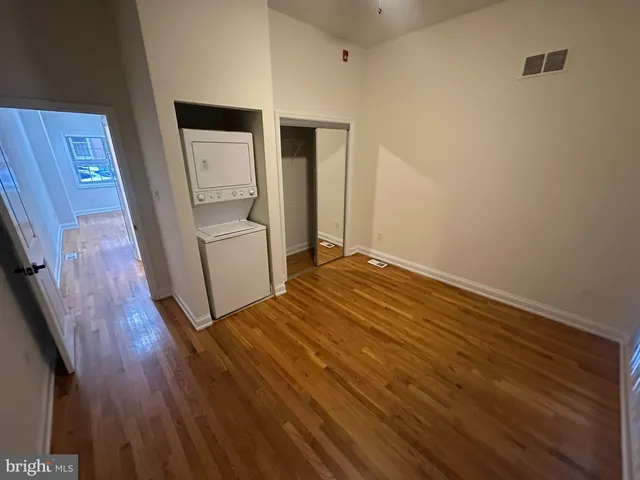a view of empty room with wooden floor