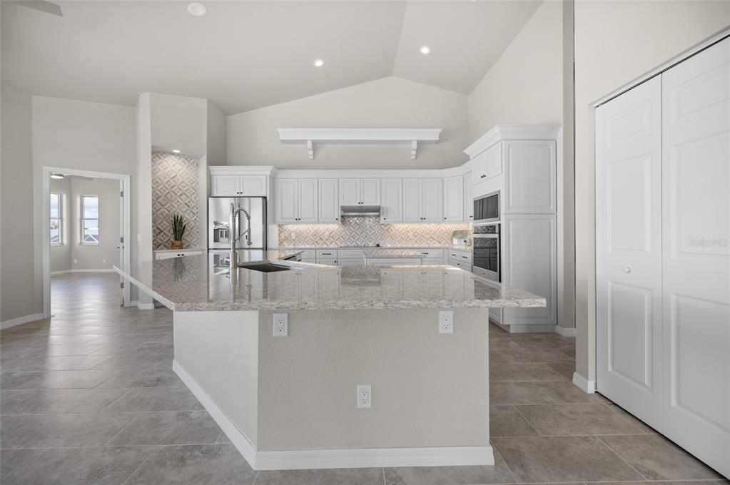 1950 Arkansas Avenue Englewood, FL 34224 - Photo 18 of 52 a view of a kitchen with kitchen island white cabinets and stainless steel appliances