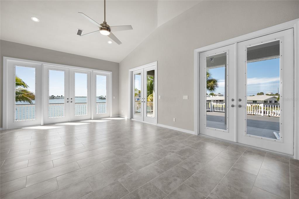 1950 Arkansas Avenue Englewood, FL 34224 - Photo 9 of 52 an empty room with large windows and a ceiling fan