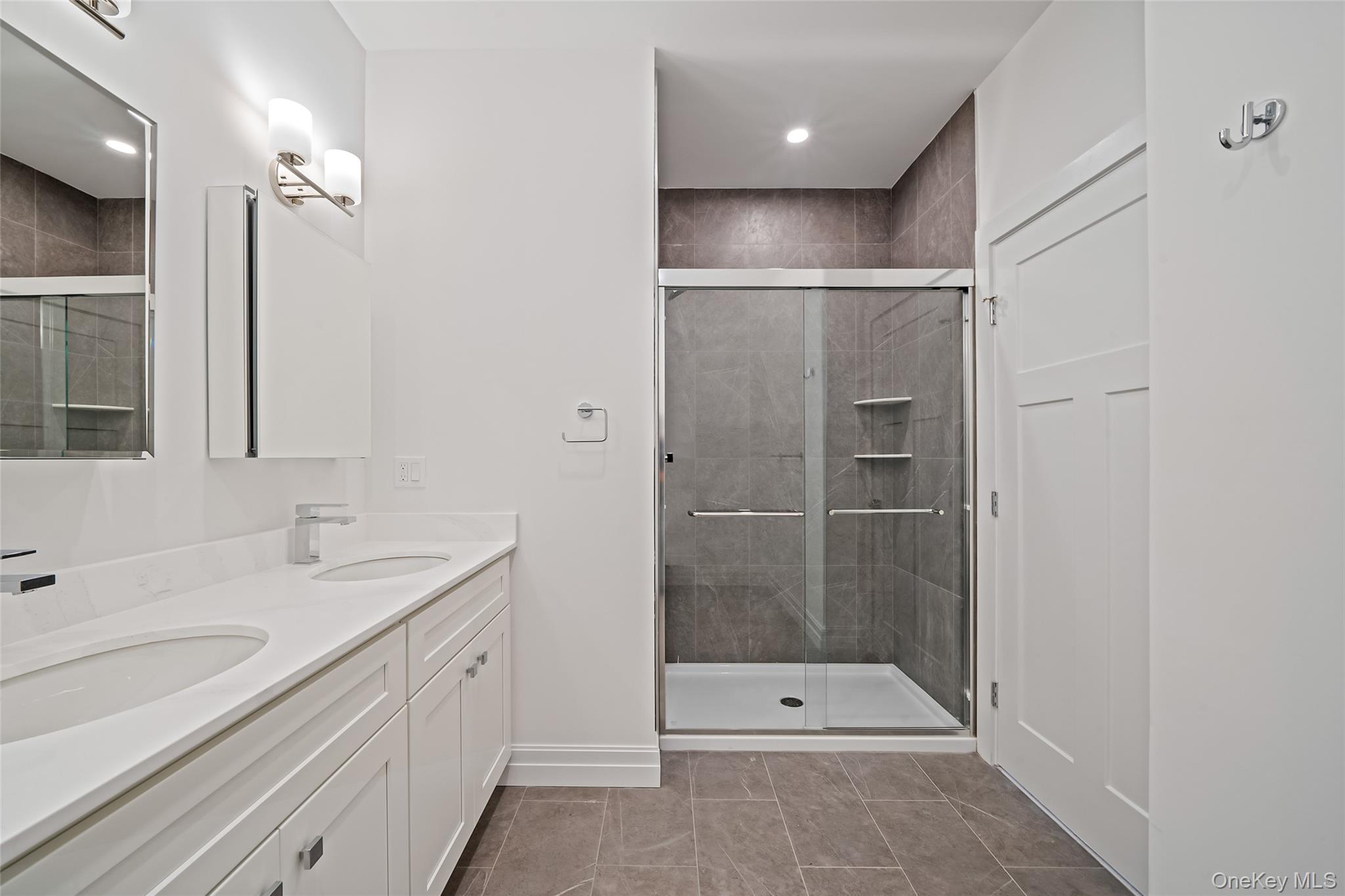 103 Dover Street Central Islip, NY 11722 - Photo 21 of 45 Full bathroom featuring a shower stall, double vanity, light tile patterned floors, and recessed lighting