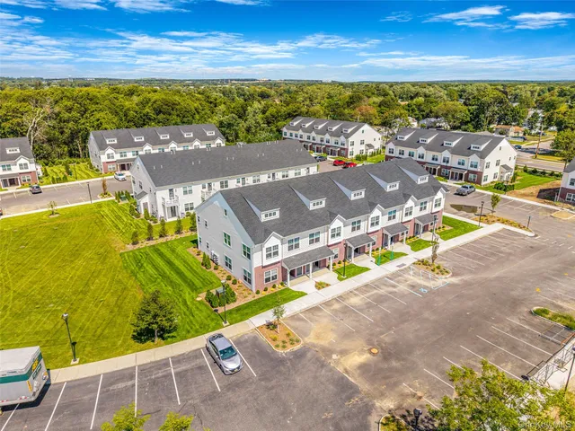 an aerial view of residential houses with outdoor space and swimming pool