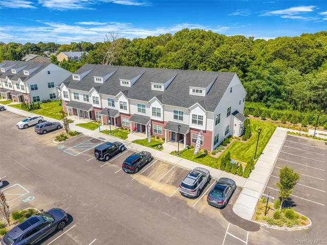 an aerial view of residential houses with outdoor space and parking