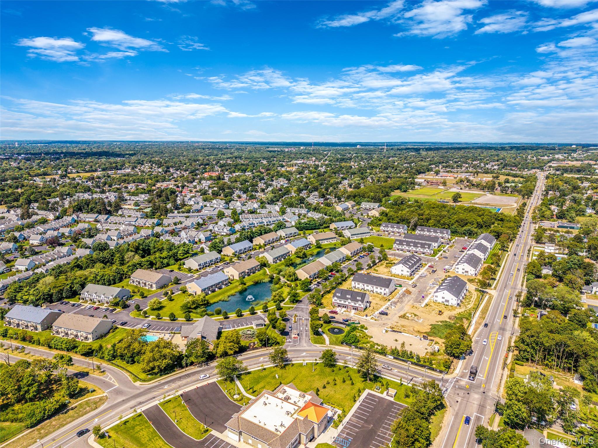 103 Dover Street Central Islip, NY 11722 - Photo 37 of 45 Aerial view of residential area featuring a nearby body of water and a tree filled landscape