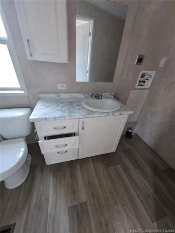 a bathroom with a granite countertop toilet sink and mirror