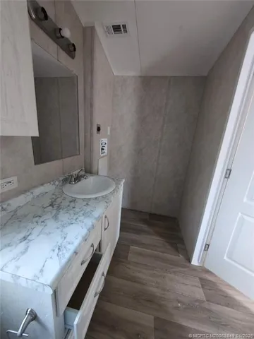 a bathroom with a granite countertop sink and a mirror