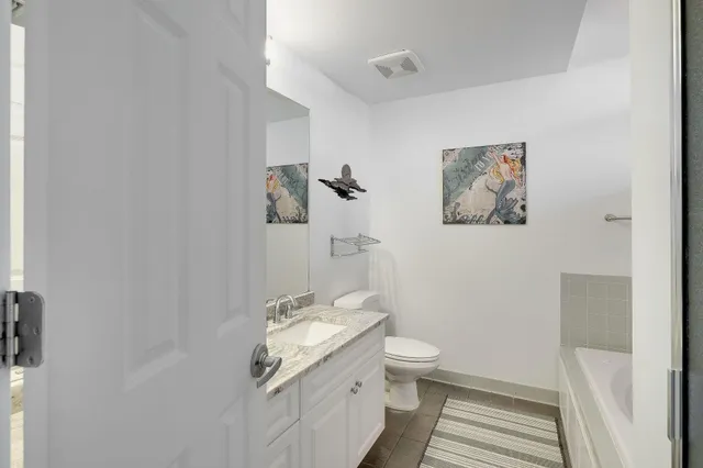 a bathroom with a granite countertop sink toilet and vanity