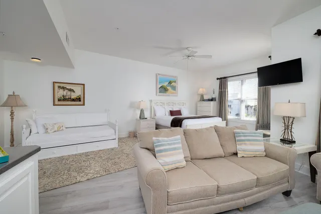 a living room with furniture a flat screen tv and a couch