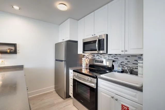 a kitchen with stainless steel appliances a stove microwave and refrigerator
