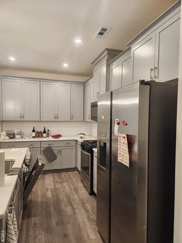 a kitchen with refrigerator and cabinets