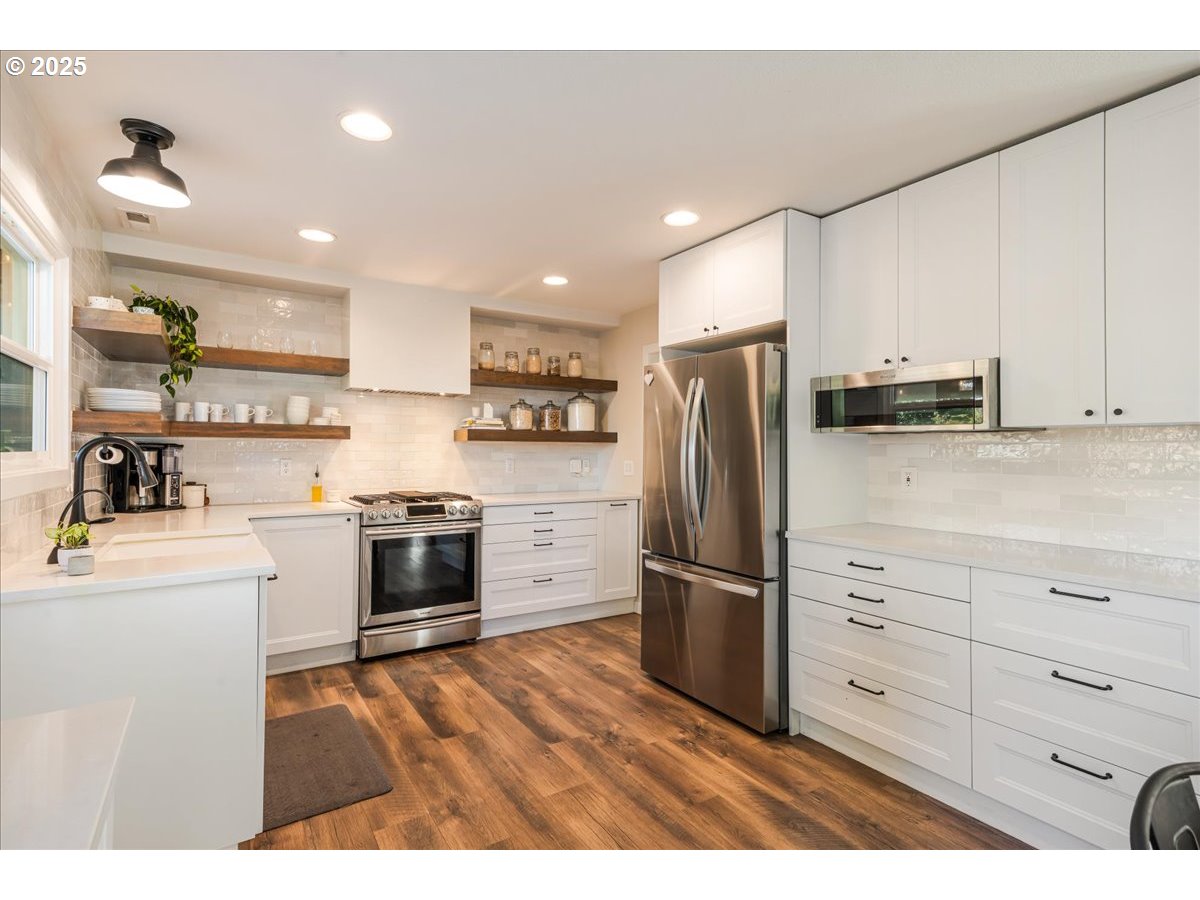 1200 Elm Lane Newberg, OR 97132 - Photo 11 of 32 a kitchen with granite countertop a refrigerator and a stove top oven