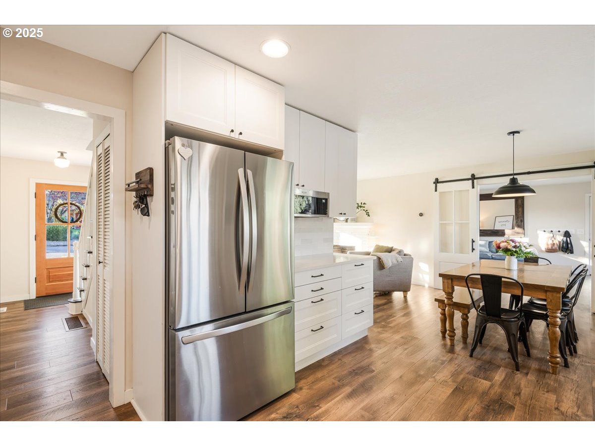 1200 Elm Lane Newberg, OR 97132 - Photo 13 of 32 a kitchen with stainless steel appliances a refrigerator a stove a dining table and chairs