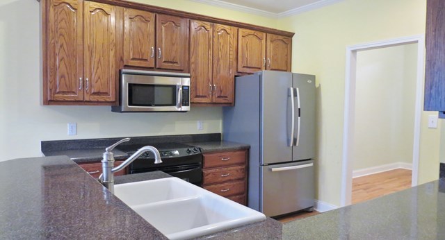 321 Eagle Ridge Road Macon, GA 31216 - Photo 7 of 23 a kitchen with granite countertop a refrigerator stove and microwave