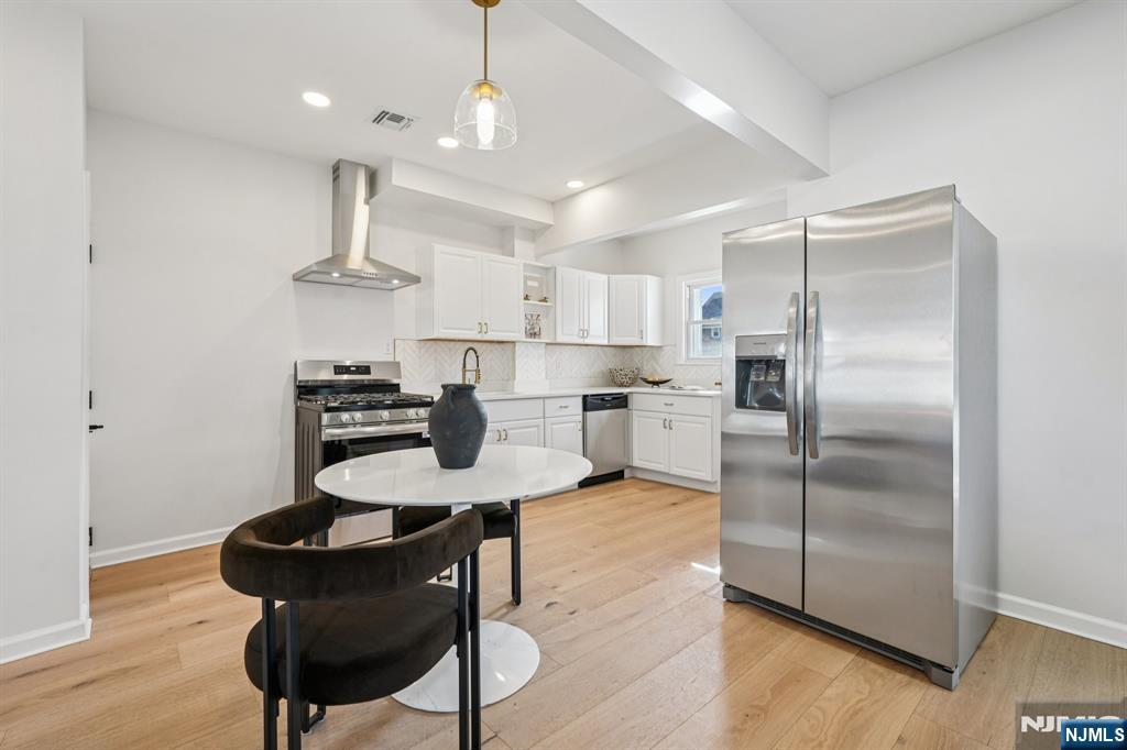 51 Highland Place Ridgefield Park, NJ 07660 - Photo 14 of 35 a kitchen with stainless steel appliances a table chairs stove and refrigerator