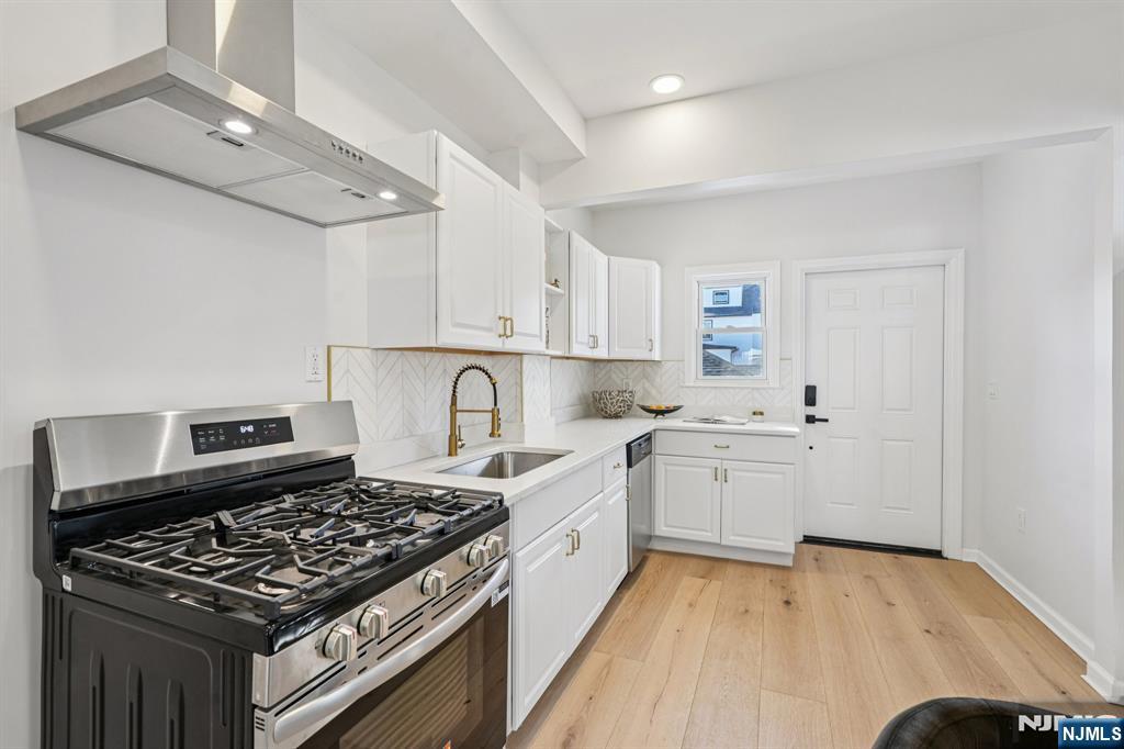 51 Highland Place Ridgefield Park, NJ 07660 - Photo 16 of 35 a kitchen with a stove and white cabinets